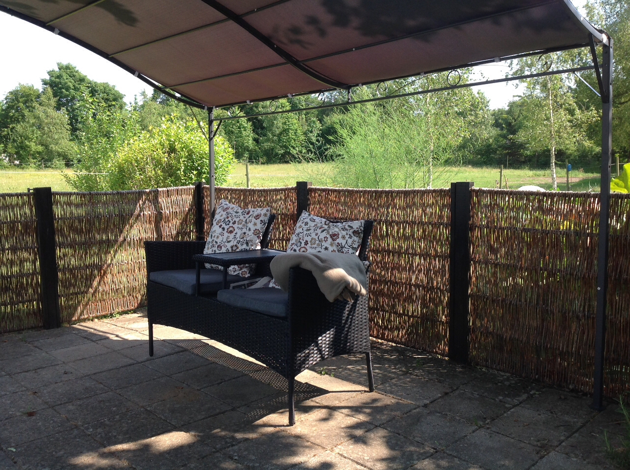 En lidt overset og kedelig terrasse har fået nyt liv. Med en lille pavillion og en fin bænk for to, er atmosfæren pludselig en helt anden. På varme dage er her svalt i skyggen, og på en lun sommeraften kan man nyde stilheden i solnedgangen. Det kan anbefales😊